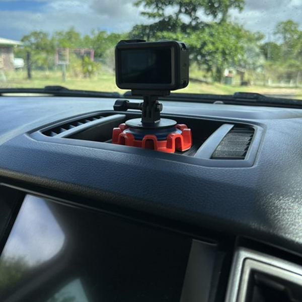 Dnoodle system mounted on a car dashboard holding a mini action camera.